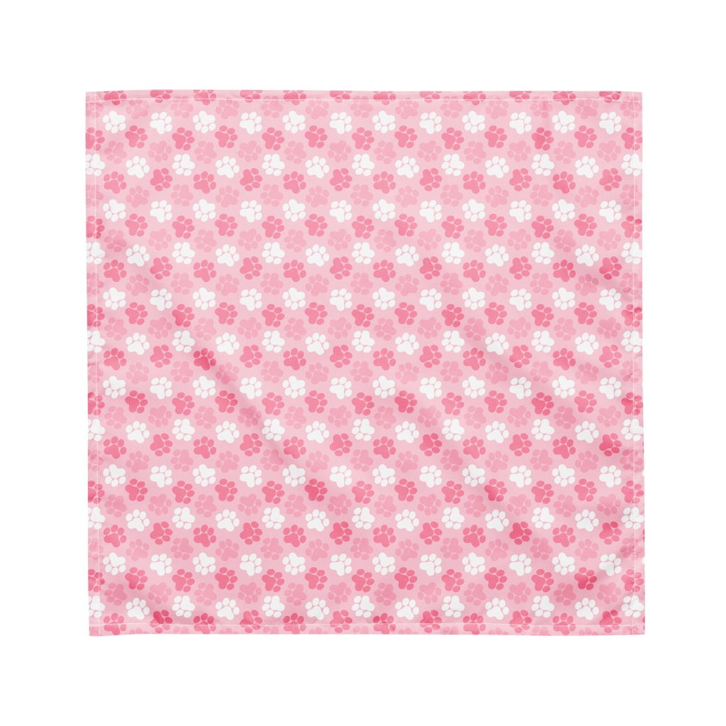 A cute pink bandana lying flat with a pink and white paw print pattern on it.