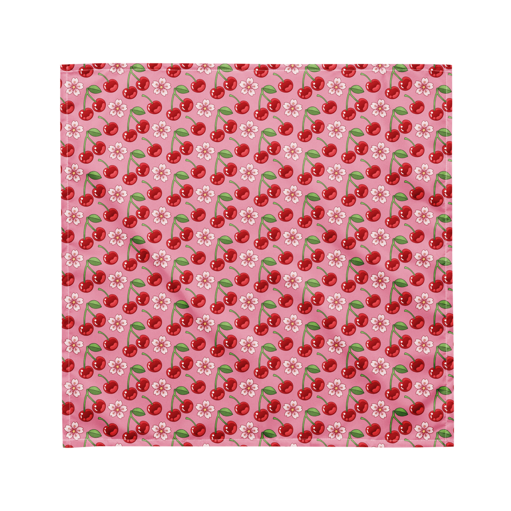 A cute pink bandana lying flat with a cherry and floral pattern on it. 