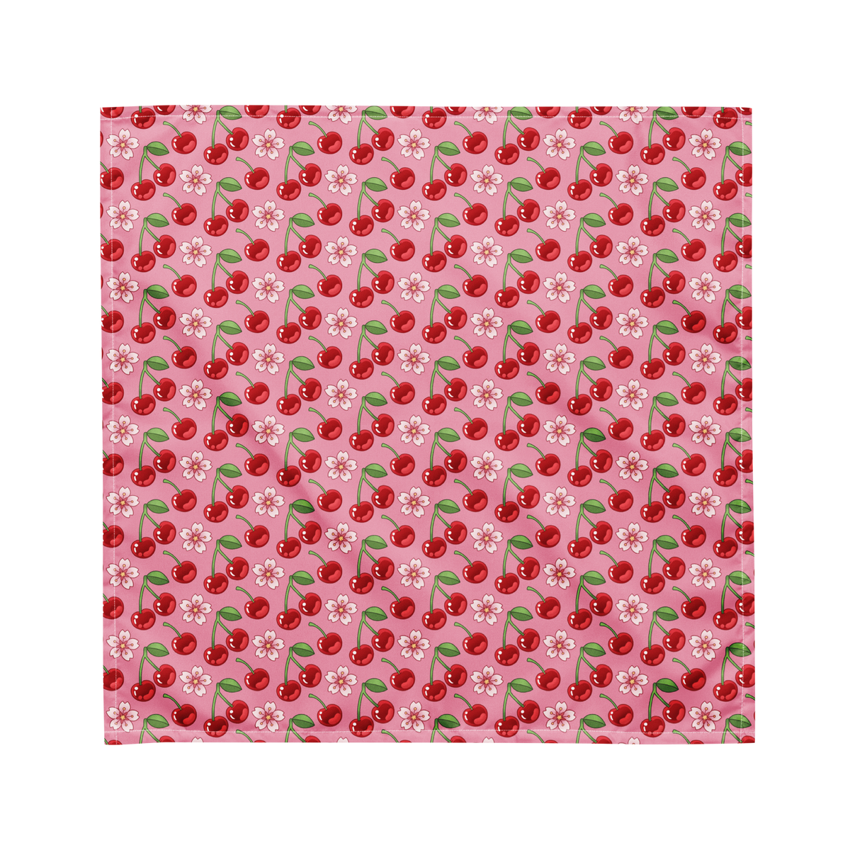 A cute pink bandana lying flat with a cherry and floral pattern on it. 