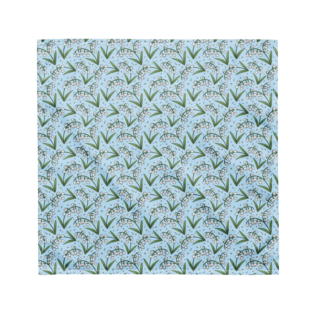 A blue bandana lying flat with a floral lily of the valley pattern on it.